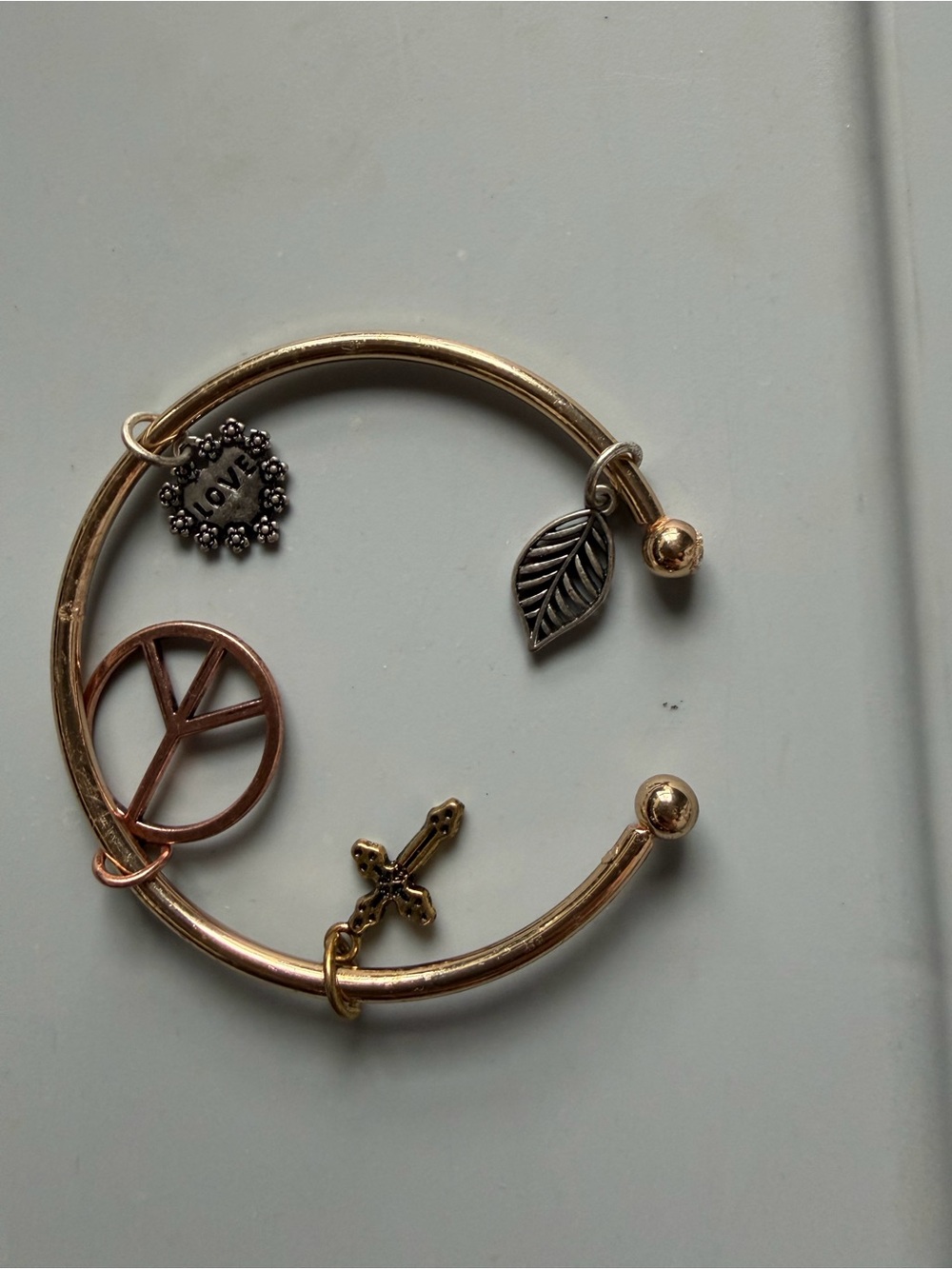 Gold-tone Charm Bangle Bracelet with Peace, Cross & Leaf Charms